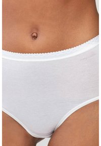 Wei�ßer Baumwollslip mit einem strukturierten Bund, der zarte, gewellte Kanten aufweist und minimales Branding an der Seite hat.