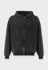 Schwarzer Kapuzenpullover mit Reißverschluss aus weichem, strukturiertem Stoff. Verfügt über eine Kapuze, Vordertaschen und ein dekoratives "J" mit Nieten auf der linken Brust.