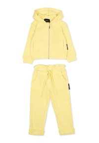 Żółta bluza z kapturem na zamek błyskawiczny, posiadająca dwie przednie kieszenie oraz pasujące spodnie z elastycznym paskiem i podwiniętymi mankietami. Miękka tkanina.