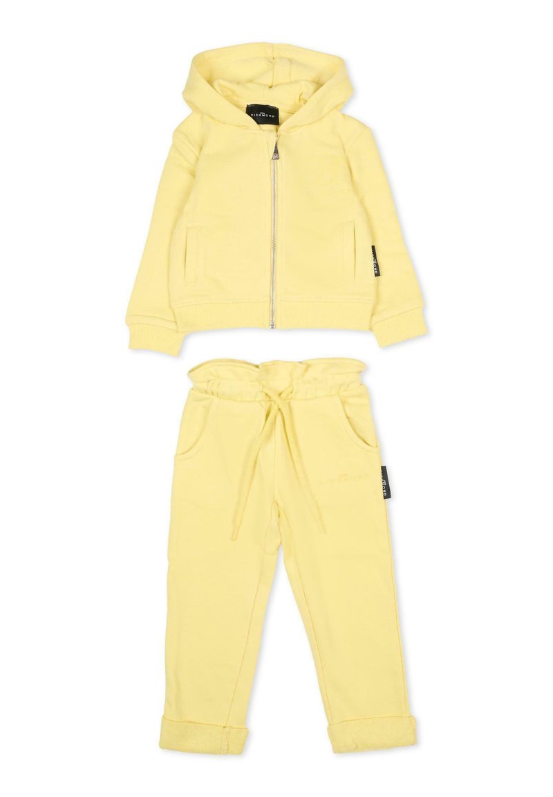 Żółta bluza z kapturem na zamek błyskawiczny, posiadająca dwie przednie kieszenie oraz pasujące spodnie z elastycznym paskiem i podwiniętymi mankietami. Miękka tkanina.