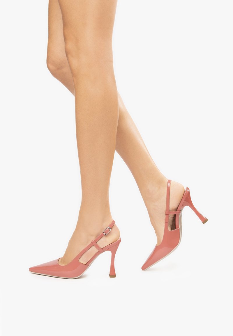 Talons slingback en cuir verni rose avec des bouts pointus, des talons effilés et des brides ajustables à la cheville. Présente des découpes de chaque côté.