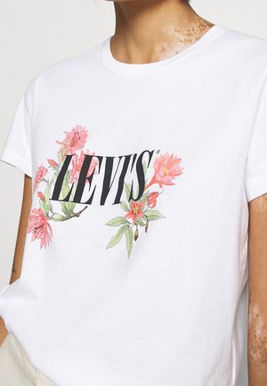 T-shirt en coton blanc avec un motif floral comprenant des fleurs roses autour du logo noir "LEVI'S". Encolure classique et manches courtes.