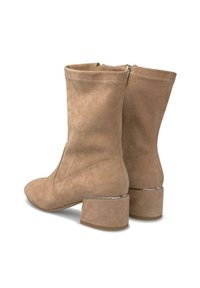 Botas de tobillo de ante beige con puntera redondeada, tacón cilíndrico y cierre de cremallera en la parte posterior. Textura suave con detalles de costura mínimos.