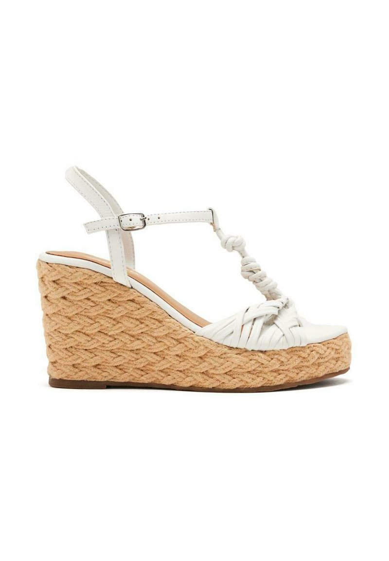 Sandales à talons compensés en cuir blanc avec une plateforme en jute tressé, dotées d'un design à tige en T et d'une boucle à la cheville réglable.