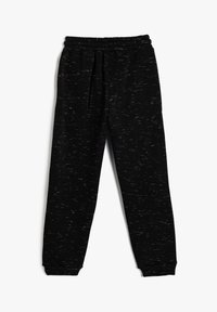 Sorte joggerbukser lavet af blødt, tekstureret stof med elastisk talje og manchetter. Har et subtilt marmoreret mønster over hele stoffet.