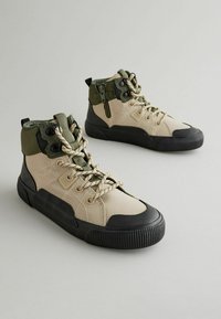 Beige und olivgrüne High-Top-Sneaker aus strukturiertem Stoff, mit schwarzen Gummisohlen und gemusterten Schnürsenkeln mit Metallösen.