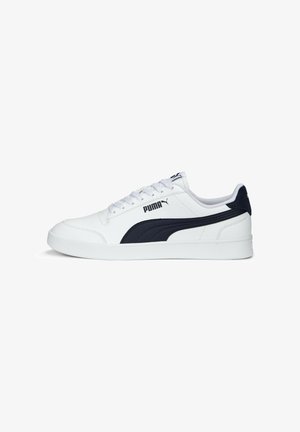 White sneaker with navy accent, smooth synthetic upper, perforated detailing, thick white rubber sole, and branded logo on the side and tongue.