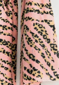 Material roz cu un model de imprimeu leopard, având pete negre și accente galbene. Textură moale cu margini franjurate vizibile.