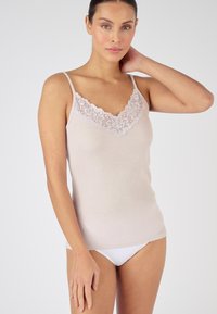 Top sin mangas de color beige claro con tirantes ajustables, que presenta un escote de encaje floral. Tela suave y ajustada, combinada con ropa interior blanca.