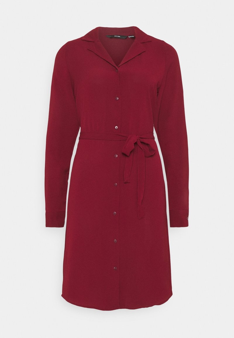 Robe boutonnée bordeaux à manches longues avec col et ceinture en tissu nouée à la taille, ourlet à hauteur des genoux, présentée sur un fond uni.