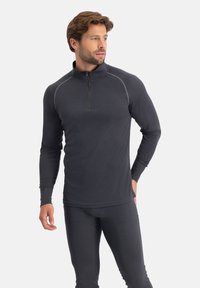 Donkergrijze lange mouw pullover met een halve rits aan de hals, gestructureerde stof en contrasterende stikdetails. Getailleerd ontwerp.