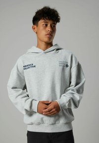 Hoodie grigio chiaro con tasca a marsupio frontale, polsini e orlo ribattuti. Presenta testo blu: "ADIENCE COLLECTIVE" e "COLLECTIVE APPAREL EDITION."