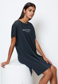 Czarna granatowa oversize'owa sukienka t-shirt z miękkiego materiału, z okrągłym dekoltem i bocznymi rozcięciami. Na przodzie widoczny tekst.