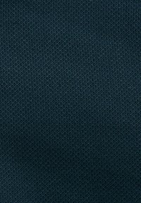 Texturerad tyg i en djup marinblå färg, med ett vävt mönster som ger en subtil, taktil yta.