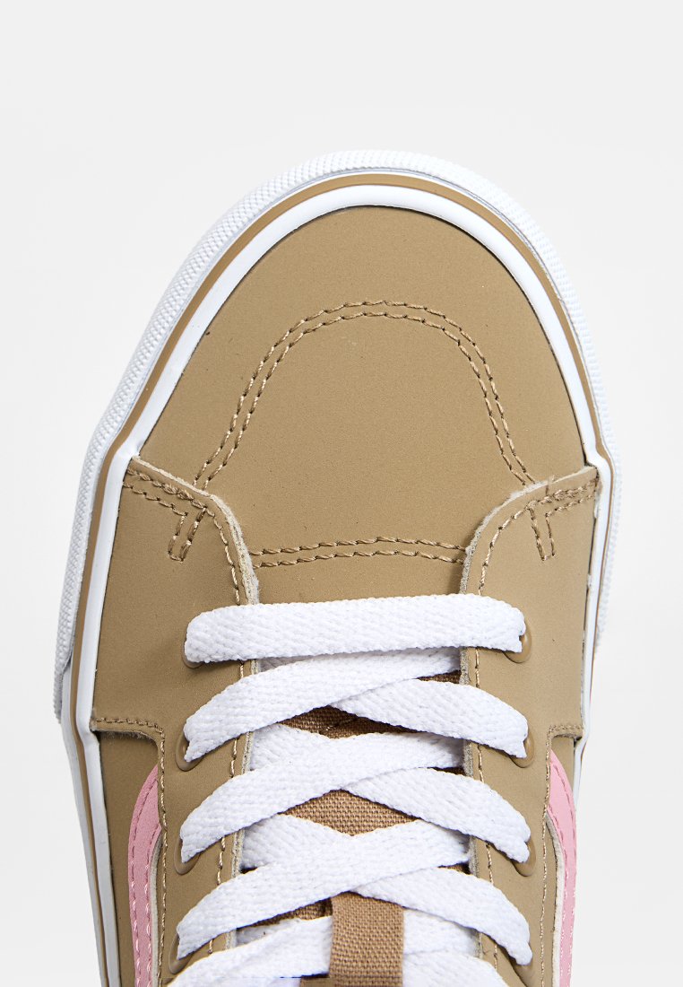 Zapatilla marrón con cordones blancos y suela de goma. Presenta un acento rosa en el costado, textura suave y costuras blancas a lo largo de los bordes.