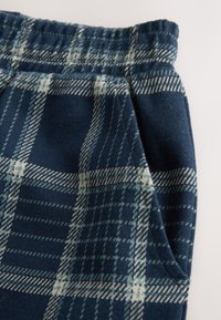 Pantaloni a quadri navy con finitura testurizzata, caratterizzati da motivi a quadretti azzurri e crema e da una vita elastica.