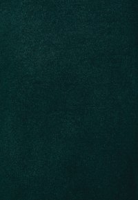 Tissu texturé vert foncé avec une sensation douce et moelleuse ; surface homogène sans motifs ni accents. Idéal pour le rembourrage ou les vêtements.