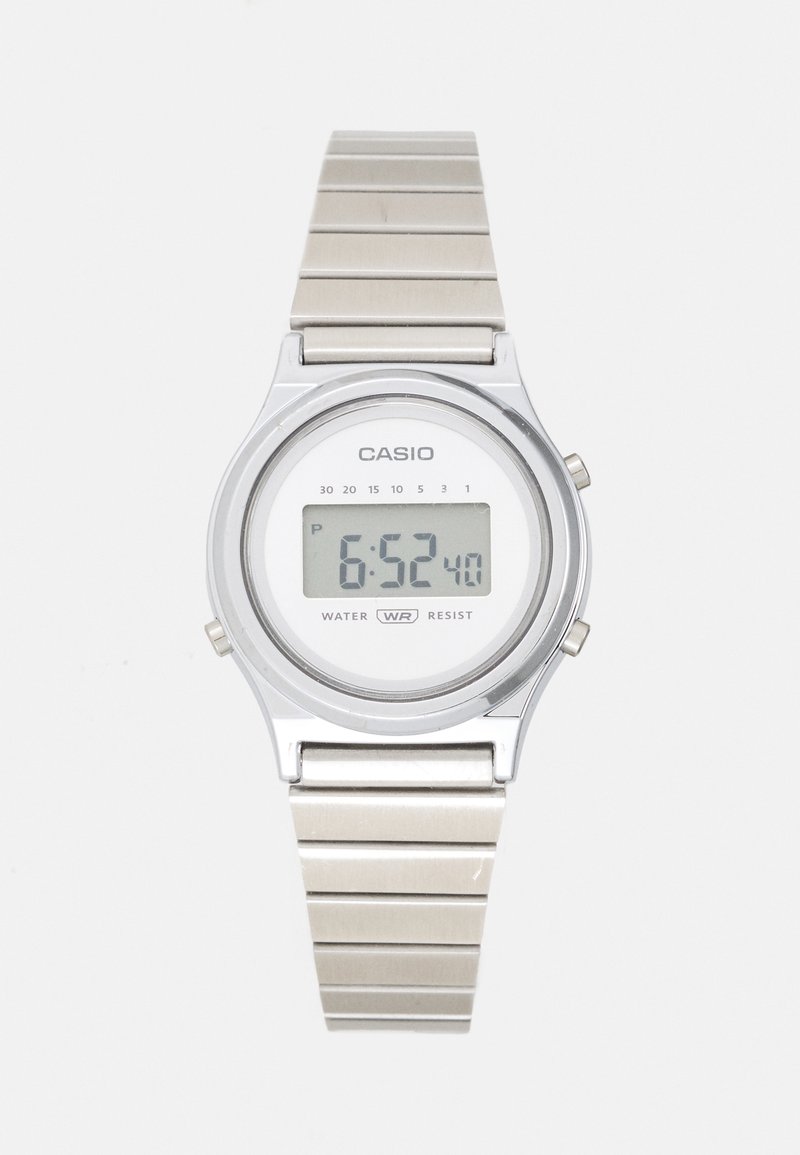 Skaitmeninis Casio laikrodis su sidabriniu metaliniu dirželiu ir apvalia korpusu. Funkcija - balta ciferblatas su LCD ekranu, rodantis 6:52. Atsparus vandeniui.