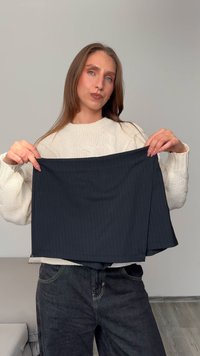 Marineblaue gestreifte Rock, der hochgehalten wird, mit glatter Textur und A-Linie-Design. Dicker Stoff mit gefaltetem Detail am Saum.