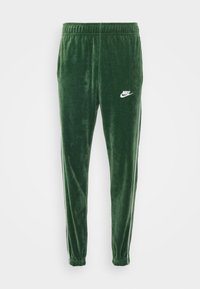 Grønne velour joggers med elastisk talje, der har hvidt Nike-logo og kontrasterende sidestriber; tapered ben-design med samlede mansjetter.