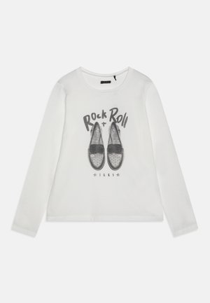 Biała koszula z długim rękawem z czarną grafiką mokasynów, nad nimi napis „Rock + Roll”, a pod butami napis „IKKS” z gwiazdkami.
