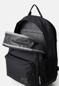 Zaino nero con interno grigio a righe, dotato di tasca frontale, tasca laterale in rete e maniglia a loop sulla parte superiore per un facile trasporto.