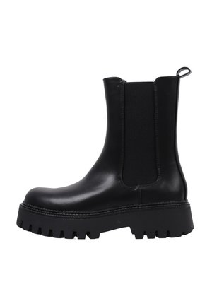 Botte Chelsea en cuir noir avec semelle épaisse crantée, panneau latéral élastique et languette à l’arrière, vue du côté extérieur.