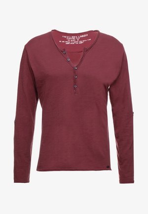 Bordeauxrotes Langarmshirt mit Henley-Ausschnitt, fünf Knöpfen und einer weichen Textur. Verfügt über ein Etikett im Inneren mit Marken- und Größenangaben.