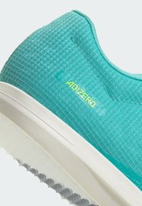 Turquoise athletic shoe with a textured upper, white midsole, and grey outsole. "ADIZERO" logo in neon green on the side.
