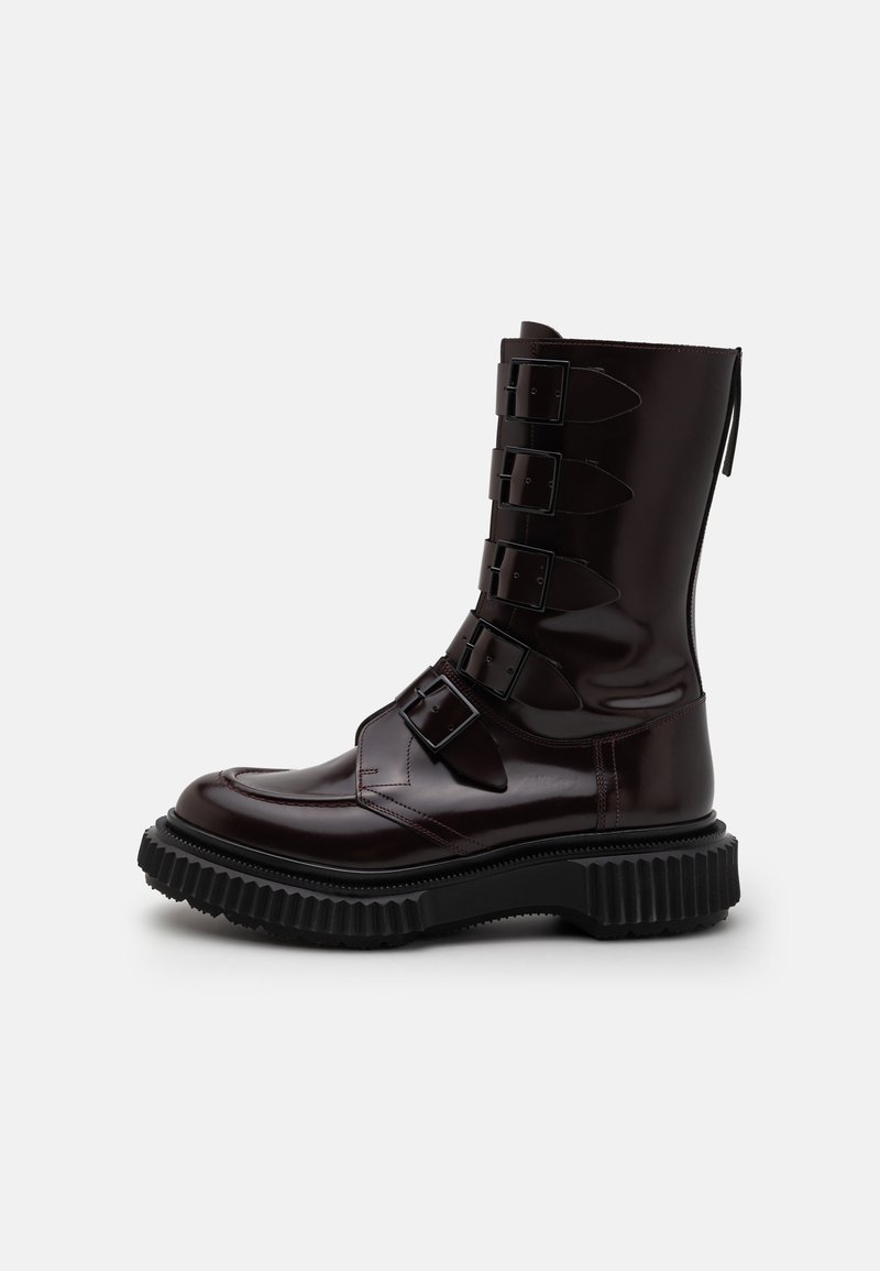 Burgundy leather ankle boot with a chunky black rubber sole, featuring five adjustable buckles along the side and a smooth finish.