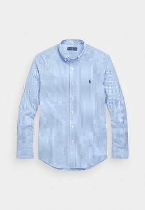 Chemise à manches longues à carreaux vichy bleu et blanc, boutonnée, col boutonné et petit logo brodé sur la poitrine gauche.