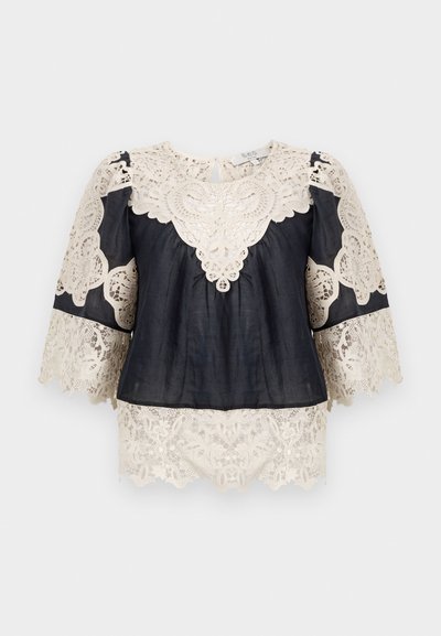 Blusa nera con intricate rifiniture in pizzo beige, caratterizzata da un collo rotondo, maniche corte a campana e orlo in pizzo decorativo.