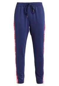 Marinblå joggingsbyxor med elastisk midja och dragsko; har röda och vita mönstrade sidostråk; slätt, lättviktigt material; tapered passform.