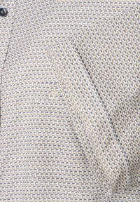 Overhemd met knoopsluiting, gemaakt van lichtbeige stof met een klein geometrisch patroon in blauwe en gouden tinten; gestructureerde kraag en manchetten.