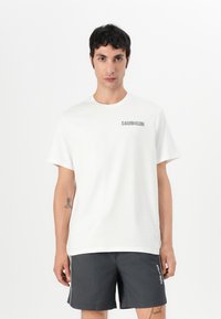 White cotton T-shirt featuring a gray "CALVIN KLEIN" logo on the left chest. Classic crew neck with short sleeves. Simple and minimalist design.