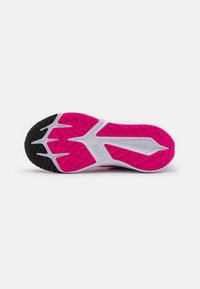 Semelle de chaussure Nike avec un bord extérieur noir, un motif d'adhérence rose et une semelle intermédiaire blanche. Présente une texture en forme de vague et une marque visible.