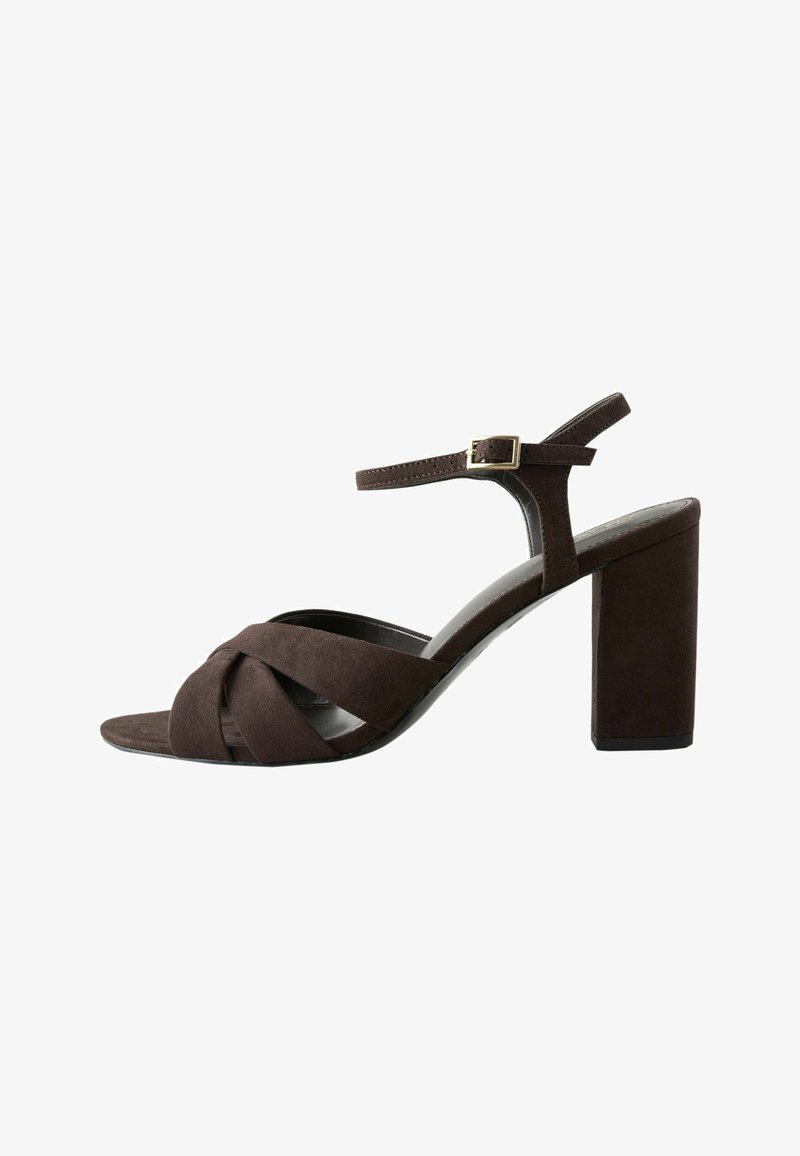 Sandale pour femmes en daim marron foncé avec talon bloc, brides croisées à l'avant et bride de cheville ajustable avec boucle dorée.