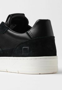 Sneaker in pelle nera e suede con suola in gomma bianca, caratterizzata da un sottile accento del logo e colletto imbottito per il comfort.