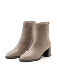 Stivali alla caviglia in pelle beige con texture liscia, punta appuntita e tacco a blocco alto e strutturato. Chiusura con cerniera sul retro.