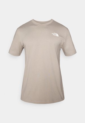 Béžové tričko s krátkým rukávem vyrobené z bavlny. Má bílý logo na hrudi, kulatý výstřih a volný střih. Hladká textura.