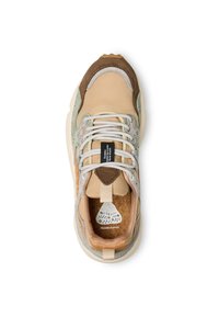 Zapatilla que combina materiales en beige, marrón y verde, con acentos texturizados, suela acolchada y plantilla decorada.