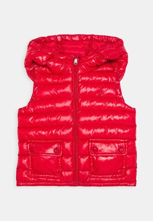 Chaleco acolchado rojo con textura brillante, cierre de cremallera, capucha y dos bolsillos frontales con botón de presión. El diseño acolchado añade aislamiento.