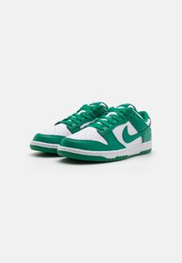 Grønne og hvide Nike sneakers med en overdel i læder og syntetisk materiale, polstret krave, perforeret tåboks og gummisål.