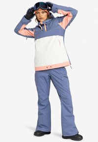 Snowboardjas in blauw, roze en wit. Voorzien van een ritssluiting aan de voorkant, verstelbare capuchon en zakken. Gecombineerd met bijpassende blauwe sneeuwbroek.