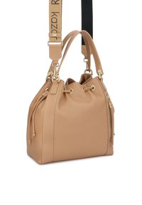 Beežist nahast ämbrikujuline kott kinnitusnööri sulgemisega, kuldse tooniga riistvara, kahepoolsed lühikesed sangad ja reguleeritav kaubamärgiga õlarihm.