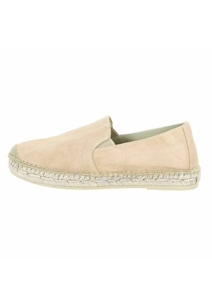 Mocassin en suède beige avec bande tissée en jute et semelle texturée, présentant un bout arrondi et un design à profile bas.