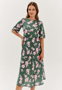 Kvetinové midi šaty v zelenej farbe s ružovými kvetinovými vzormi, krátke rukávy a sťahovaný pás, vyrobené z hladkej látky s voľným strihom.