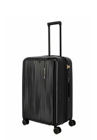 Maleta rígida negra con relieves verticales, cuatro ruedas giratorias, asa telescópica y cerradura combinada lateral.