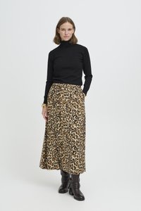 Black turtleneck sweater paired with a leopard print maxi skirt. The skirt features a gathered waist and pockets. Model wears black boots.