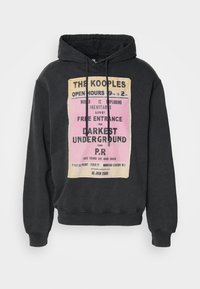 Felpa nera con cappuccio realizzata in tessuto morbido, caratterizzata da una grande grafica stampata in rosa e giallo con testo. Include un cordino e polsini a costine.